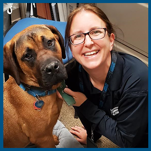 5x5 blue border Shannon Harkey with brown dog on office floor