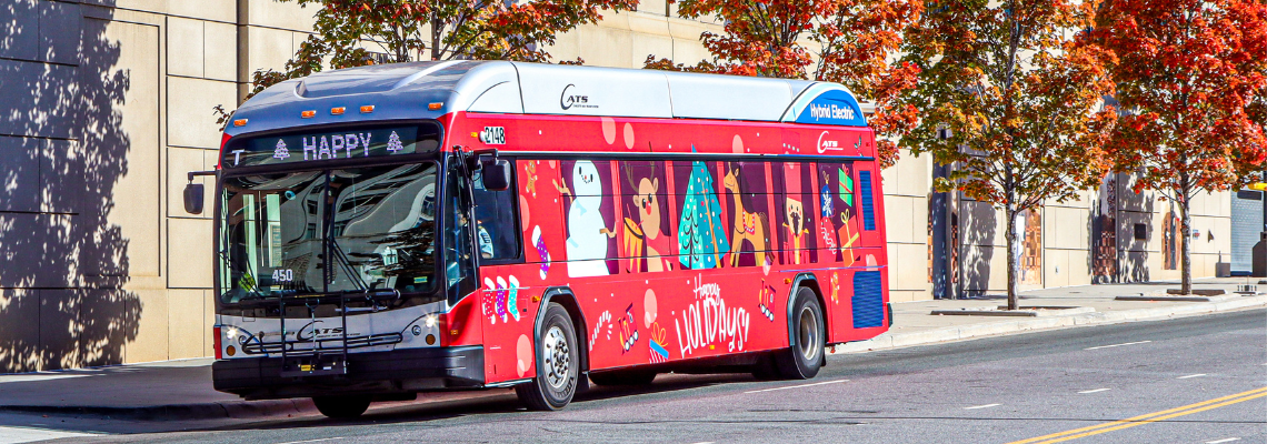 Holiday Bus driving down the road in update. Wrapped in a holiday theme vinyl. 