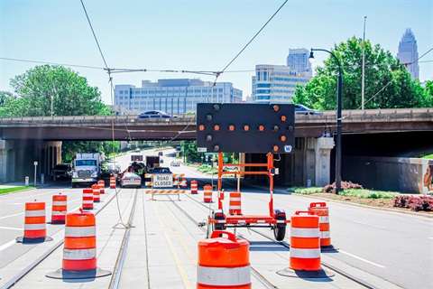 Orange traffic cones surrounding an LED sign with an arrow point to the right