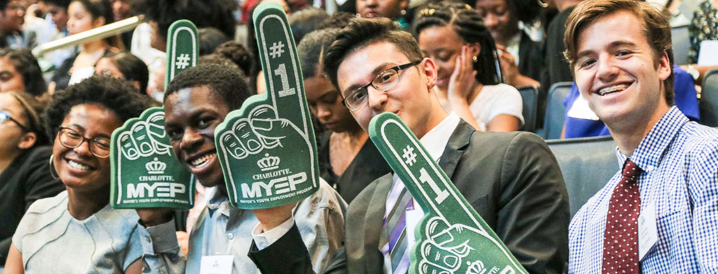 MYEP Students smiling at the camera while holding #1 hand props at the MYEP Kickoff event.