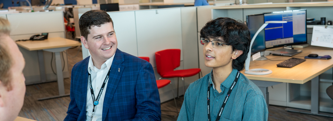 MYEP intern Sharvil sits with Ryker Thompson at CLT airport during his internship with American Airlines. Both are smiling.