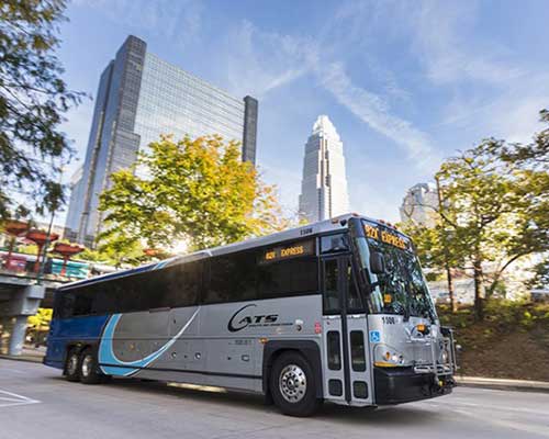 Transit bus driving through down town charlotte mid day 