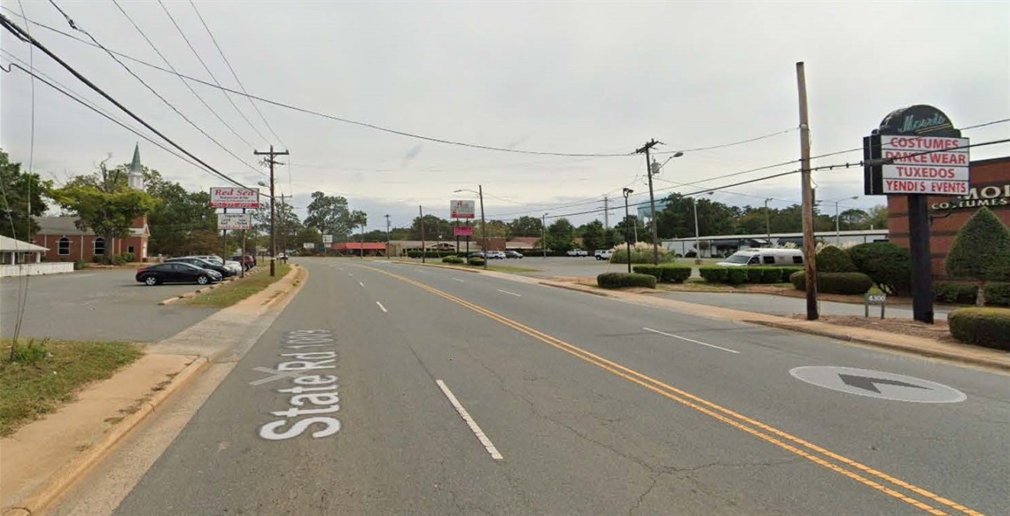 photo of existing road with sidewalk up against the curb on both sides of the road