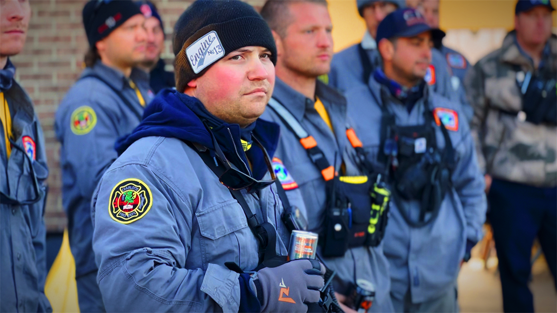 Firefighter Jacob Melton listens intently during a morning briefing, fully prepared for another day of relentless efforts in Yancey County's recovery.