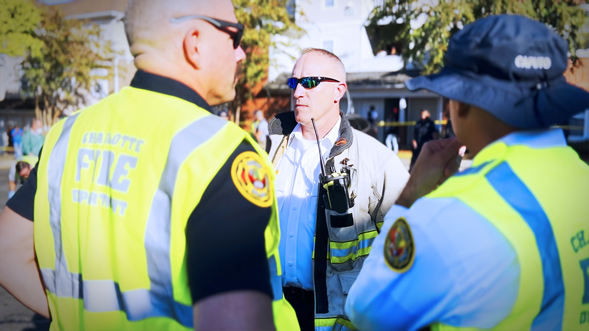 Deputy Chief Pete Skeris is briefed by Field Technician and Division Chief, highlighting the essential role of the Field Technician program in providing Chief Officers with up-to-date information and logistical support during critical operations. 