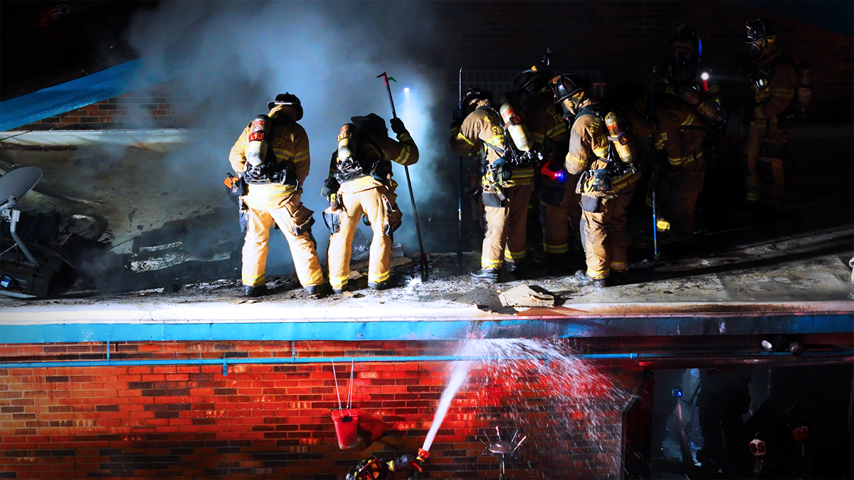 Firefighters work through the night to contain a blaze, assisted by the oversight and coordination provided by Field Technicians. The Field Technician program enhances safety, allowing firefighters to focus on their tasks. 