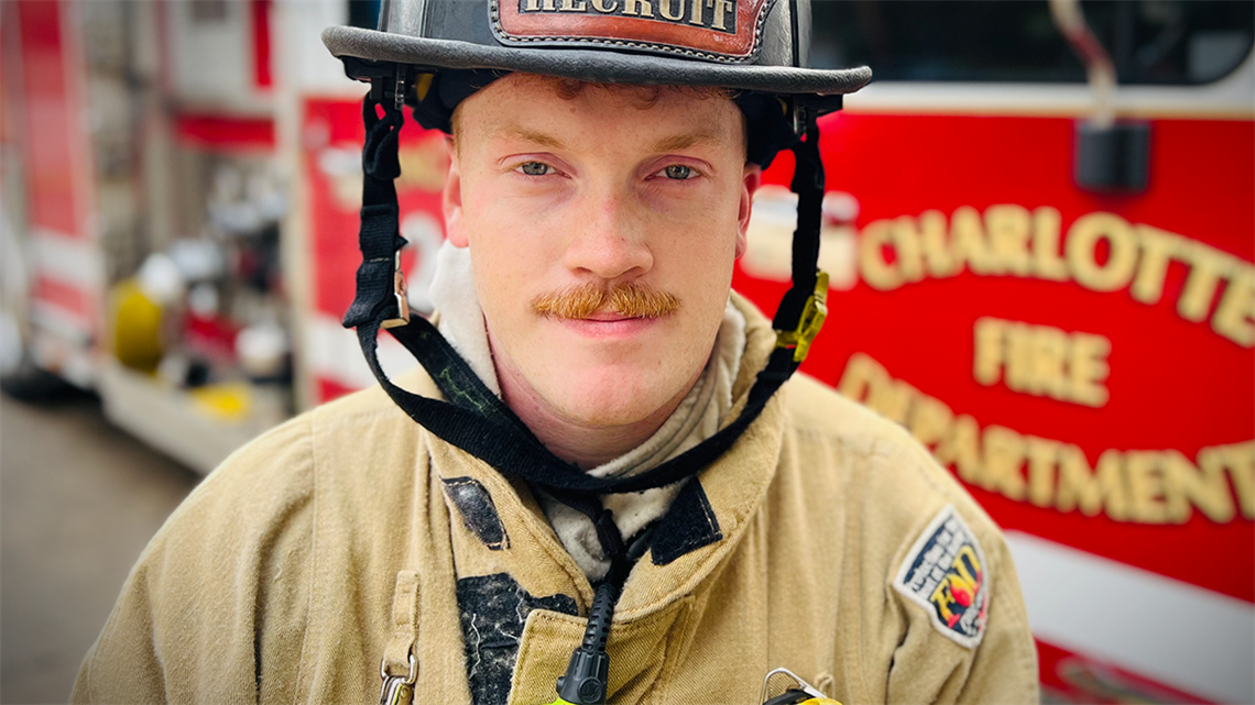 Gabriel Howard wears his Charlotte Fire recruit helmet with pride, reflecting his commitment to service. His dual role as a firefighter and National Guard member showcases his dedication to helping others in times of need. 