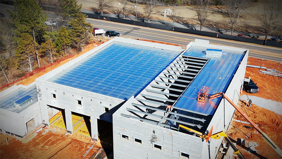 Aerial view of Firehouse 30's progress, showcasing the expansive roofing structure under construction. 