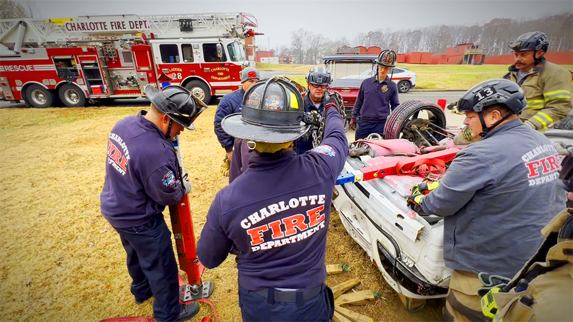 Charlotte firefighters work together to secure an overturned vehicle using Rescue 42 struts during a ladder company training session. This exercise highlights the importance of teamwork and precision in real-world rescue scenarios. 