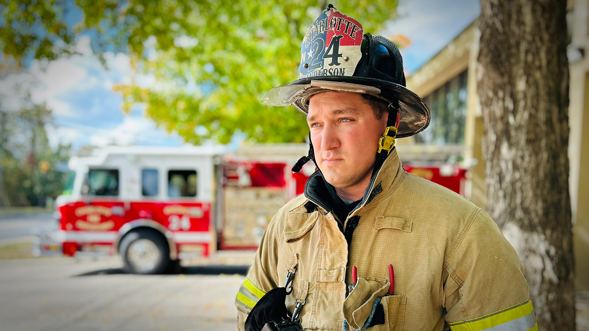 Anderson in front of Firehouse 24, representing the resilience and bravery of Charlotte Fire’s first responders. 