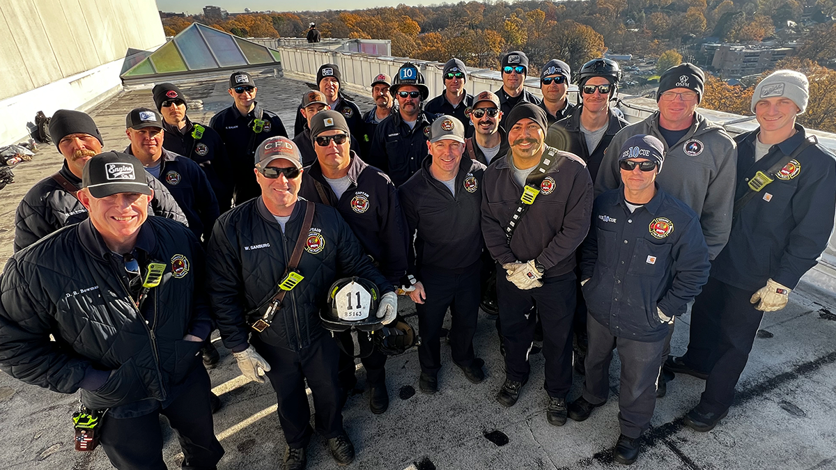 El equipo de operaciones especiales de bomberos de Charlotte se reúne en el techo para una foto de equipo antes de comenzar su conmovedor descenso.