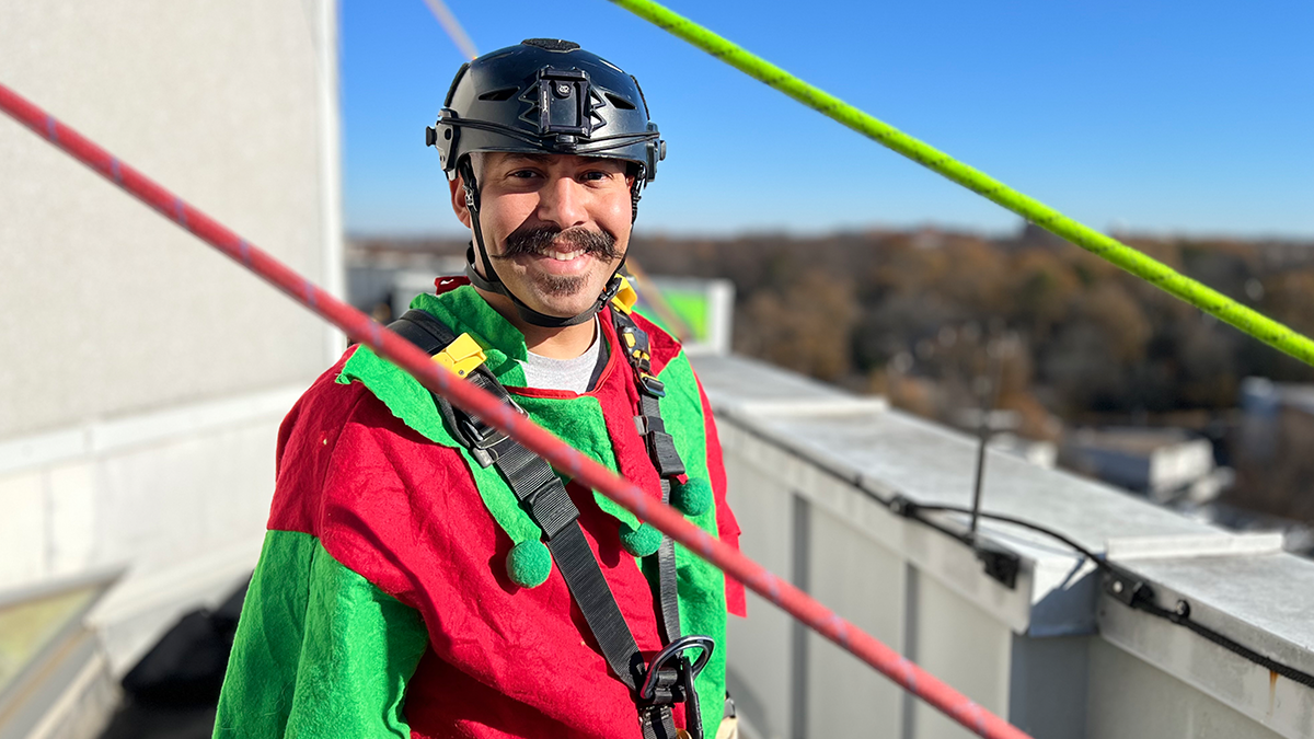 El bombero Héctor Rivera, vestido de duende, se prepara para llevar sonrisas a los pequeños pacientes con un alegre rappel navideño.