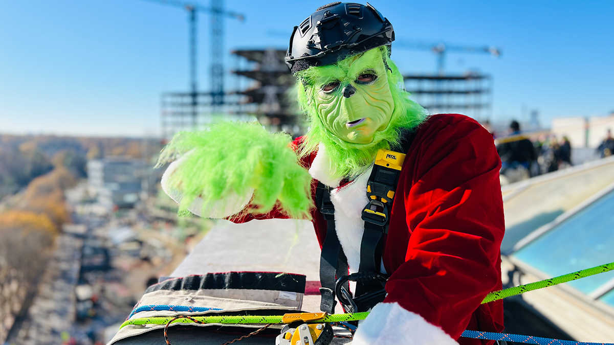 The Grinch waves from the rooftop, ready to bring a bit of mischief and a lot of joy to the children of Levine Children’s Hospital.