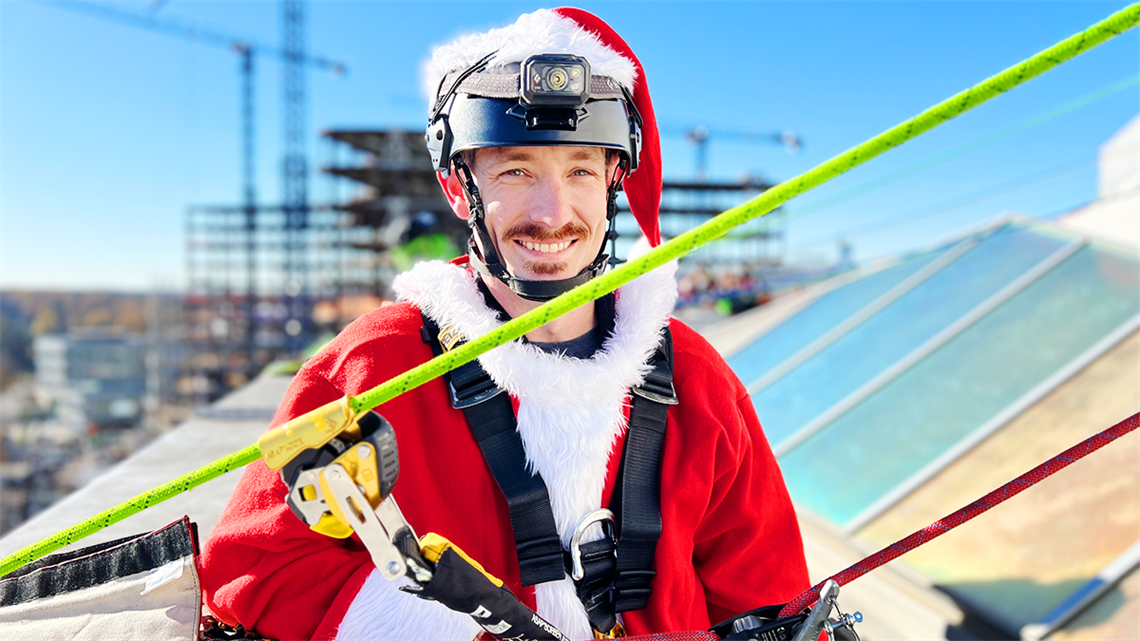 Firefighter Dustin Reynolds, dressed as Santa, beams with holiday spirit as he prepares for the highlight of the season: rappelling for a cause. 