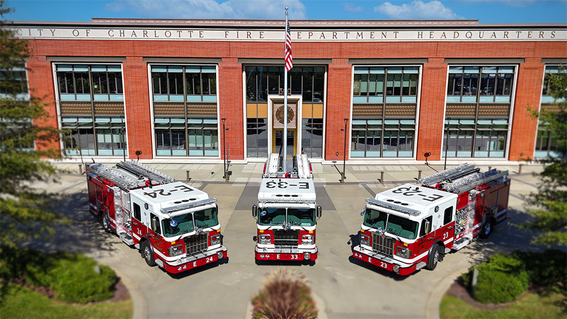 Three new Charlotte Fire engines, proudly lined up in front of Charlotte Fire Headquarters, ready to serve and protect a growing city.