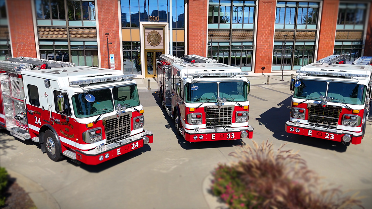 The latest additions to Charlotte Fire's fleet, Engines 24, 33, and 23, housed and ready for action in front of the iconic headquarters building. 