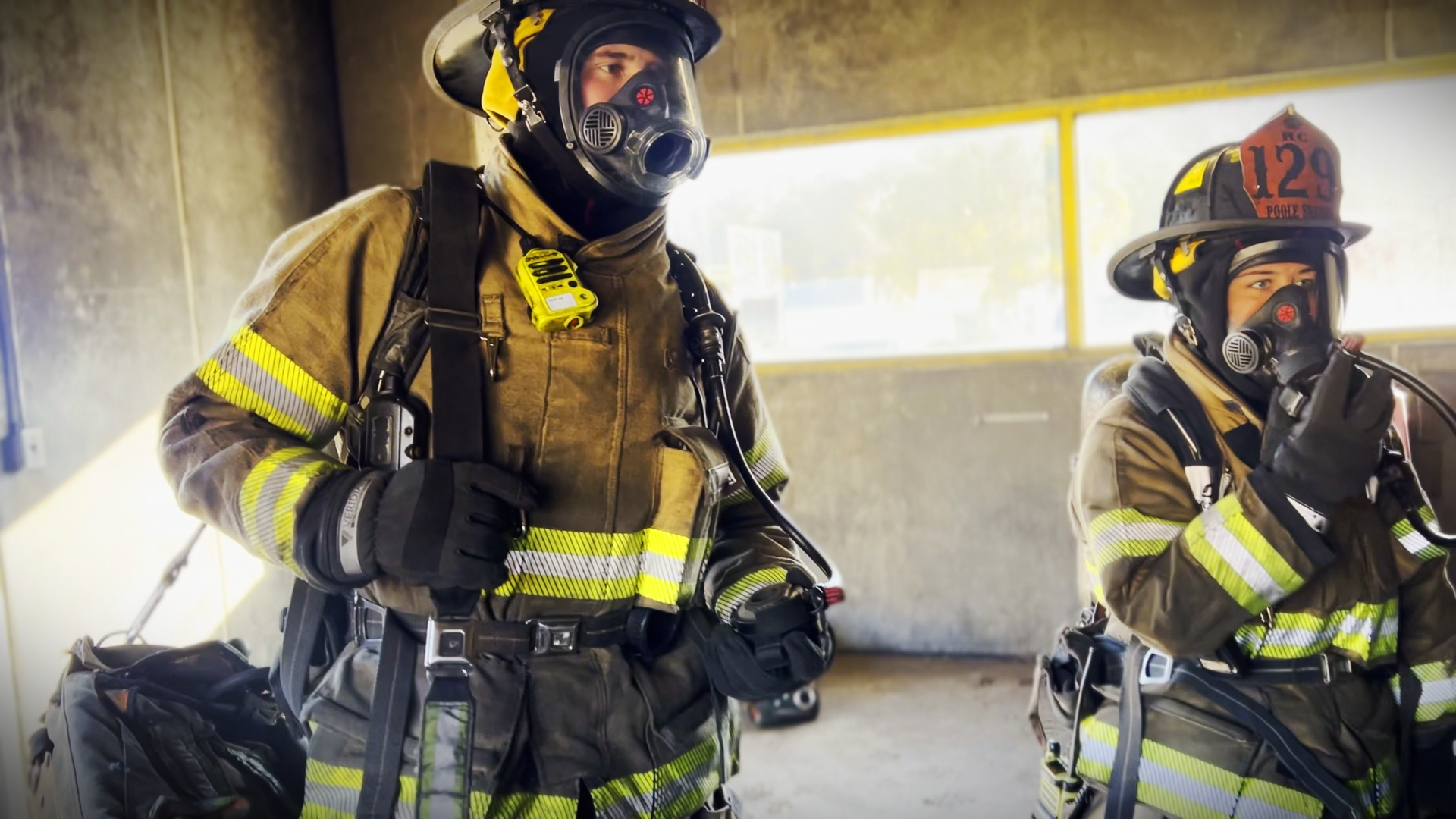 Two recruits work through a high-stress exercise, calling Maydays and coordinating rescues inside a simulated fire environment.