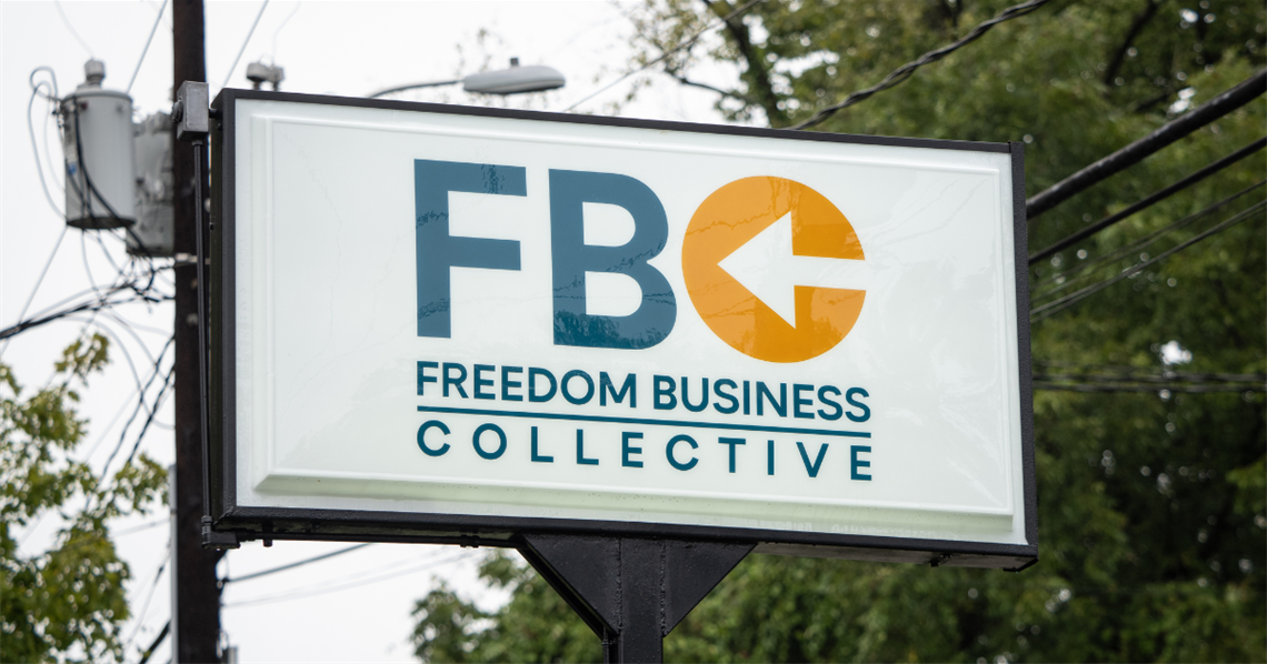 Sign with the Freedom Business Collective logo that can be viewed from the street.