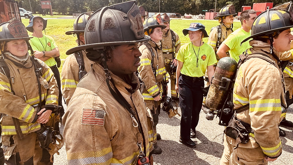 Captain Cook, surrounded by fully geared recruits, prepares to lead a training session.