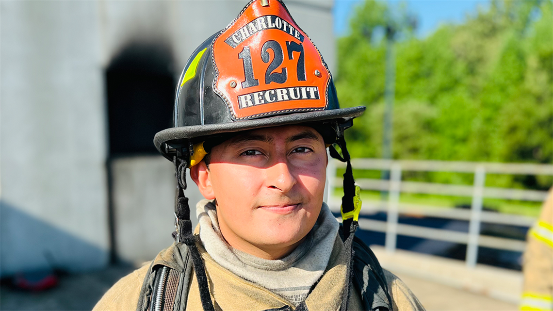 Mauro Samayoa-LaForgia looks into the camera with a soft smile while he trains as a Charlotte Fire recruit.