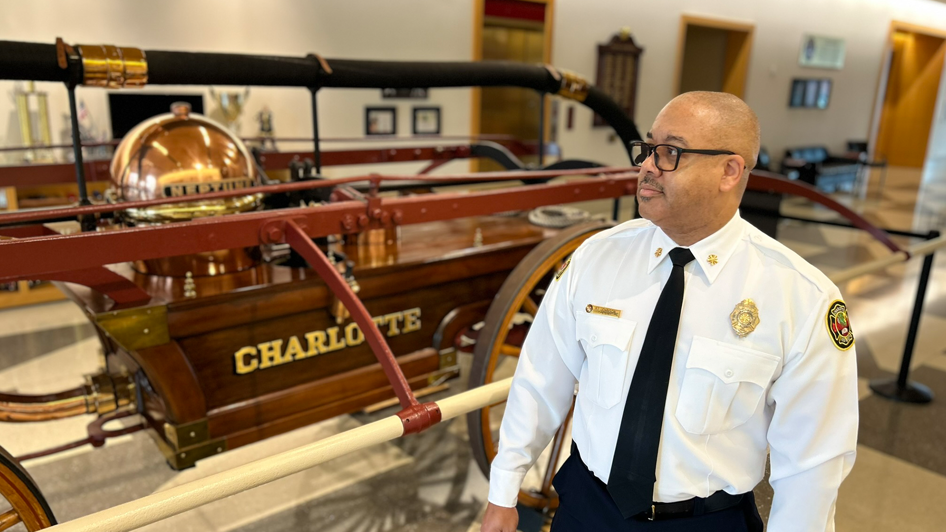 Charlotte Fire Chief Reginald T. Johnson in front of the Neptune pumper at Charlotte Fire headquarters.