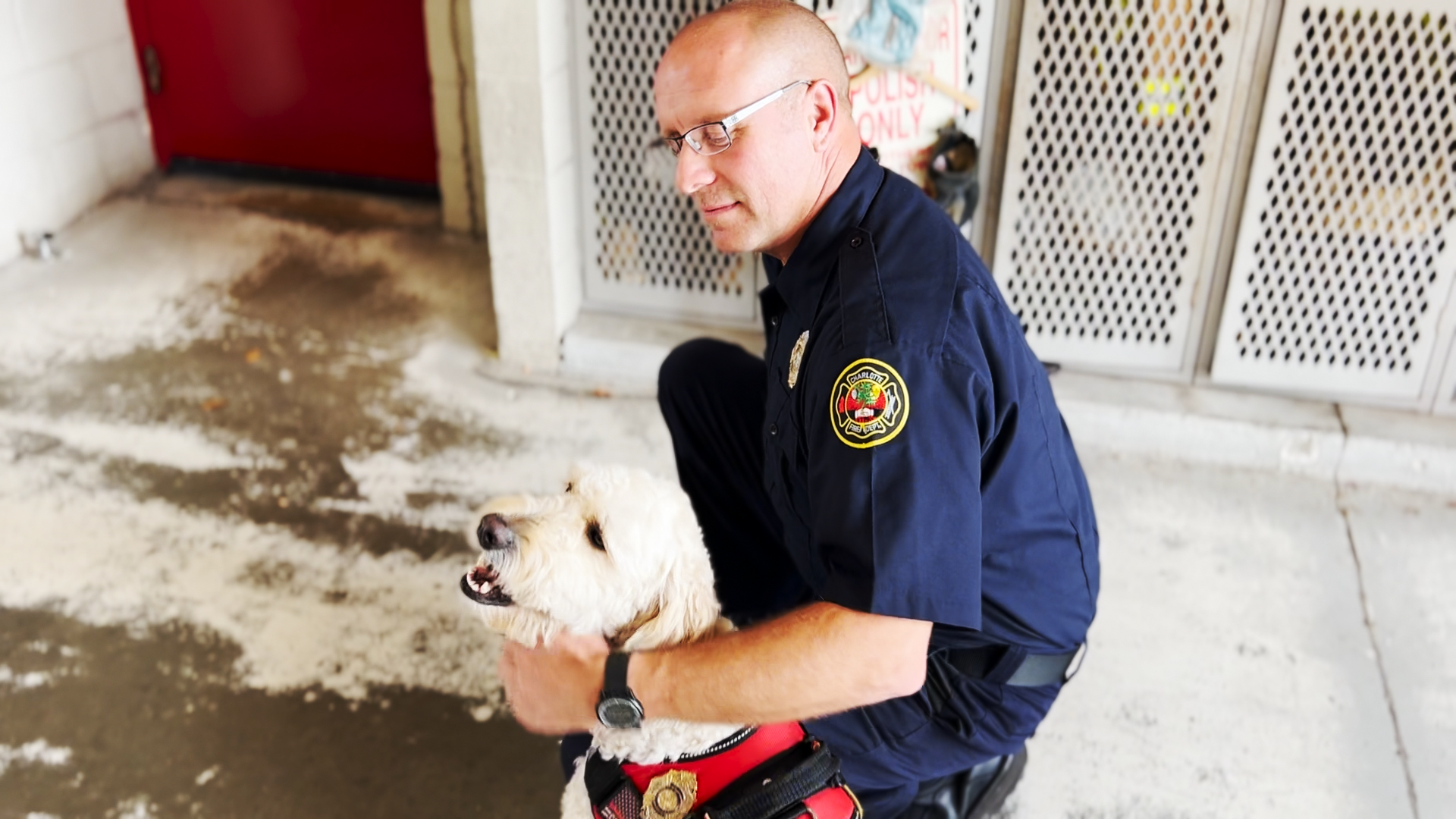 Wiatrowski kneels next to a smiling Phoenix in Firehouse 27.
