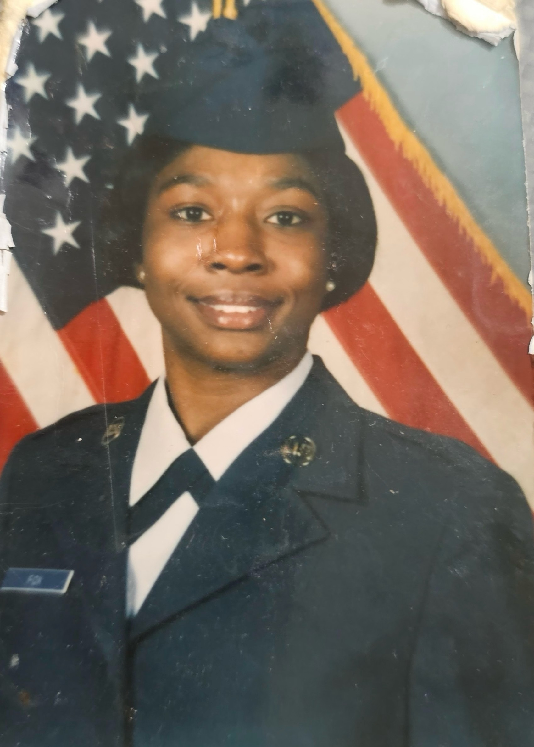 Veteran Tijuana Fox in uniform, posing in front of the American flag for an official portrait.